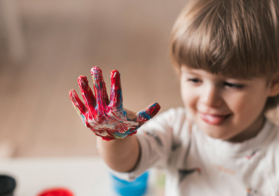 دست های رنگی کودک در حال رنگ بازی